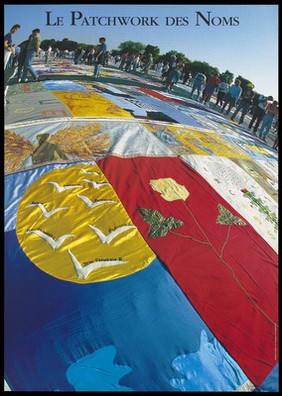 People looking at sections of the AIDS memorial quilt in a park. Colour lithograph.