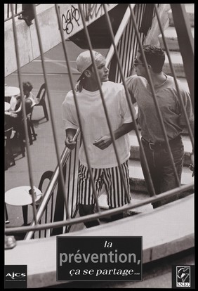 A man in striped shorts and a cap walks down some stairs with another man representing an advertisement for AIDS prevention by AJCS (Association des Jeunes contre le SIDA) and the S.N.E.G. [Syndicat National des Entreprise Gay]. Lithograph.