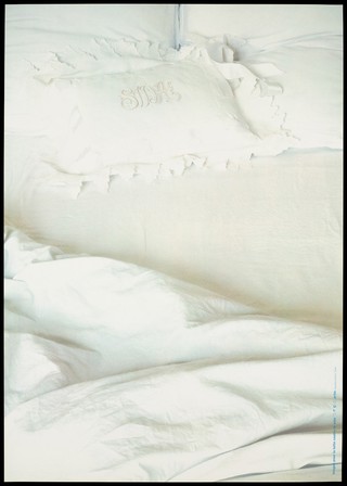 A bed with cream linen and a pillow case bearing the words 'SIDA' (AIDS) representing the transmission of AIDS in the bedroom. Colour silk screen print after J. Sterbak, 1993.