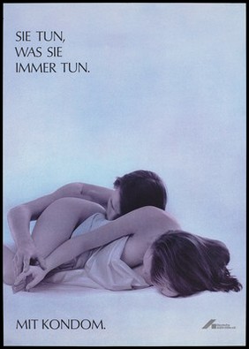 A naked man lies beside a naked woman with a sheet wrapped around her; he holds her hand in which she holds a condom packet; an advertisement for safe sex by the Deutsche AIDS-Hilfe. Colour lithograph.