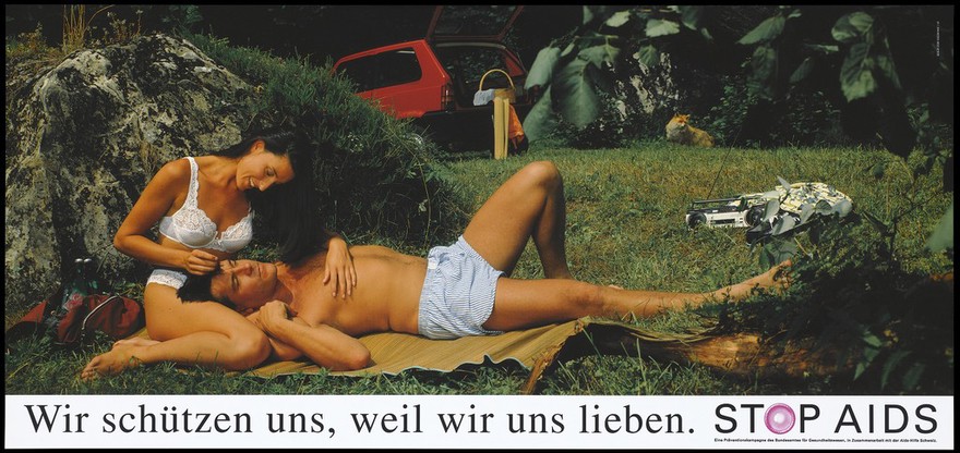 A woman in white underwear strokes the hair of a man lying down wearing boxer shorts with a portable radio, their car and a fox in the undergrowth nearby; two packs of red condoms lie in a bag to the left; German version of a series of safe sex 'Stop AIDS' campaign posters by the Federal Office of Public Health in collaboration with the AIDS-Hilfe Schweiz. Colour lithograph.