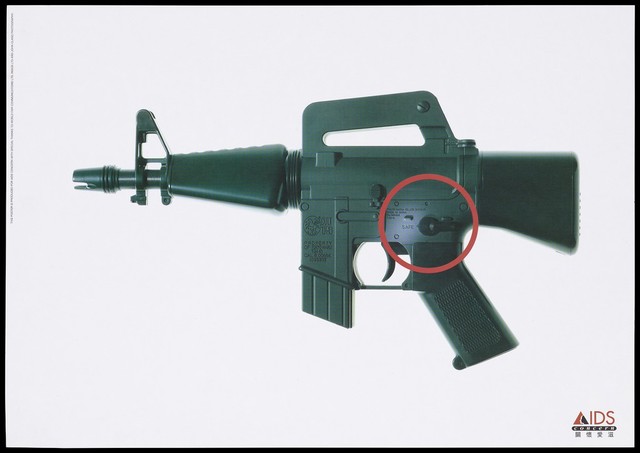 A gun with the 'safe' catch highlighted within a red circle representing a safe-sex advertisement by AIDS Concern, Hong Kong. Colour lithograph by John Clang Photography, ca. 1997.