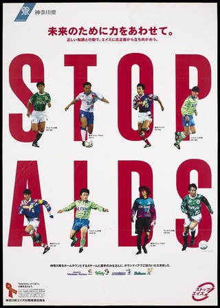 Eight Japanese footballers standing in front of the large red letters 'Stop AIDS'; an AIDS prevention advertisement by an AIDS prevention organisation in Kanagawa, Japan. Colour lithograph, 199-.