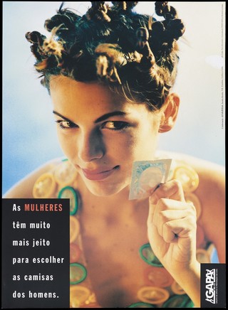 A woman with twisted plaits, wearing a necklace of coloured condoms, holds up a condom packet with a smile; a safe-sex and AIDS prevention advertisement by Gapa RS. Colour lithograph by Sandra Bordin, ca. 1996.