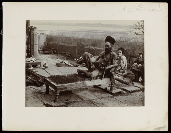 Benares, India: a fakir sitting on a bed of nails. Photograph by R.C. Mazumdar, ca. 1900 (?).