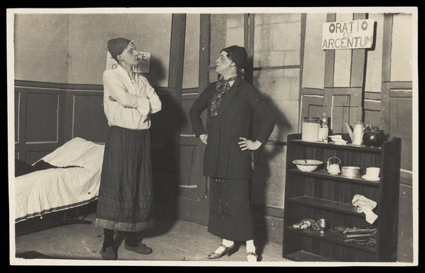 Two amateur actors, both in drag, confront each other on stage. Photographic postcard, ca. 1918.