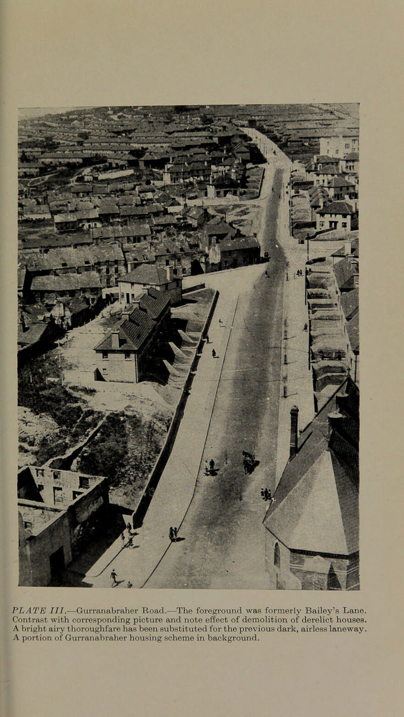 PLATE III.—Gurranabraher Road.—The foreground was formerly Bailey’s Lane. Contrast with corresponding picture and note effect of demolition of derelict houses. A bright airy thoroughfare has been substituted for the previous dark, airless laneway. A portion of Gurranabraher housing scheme in background.