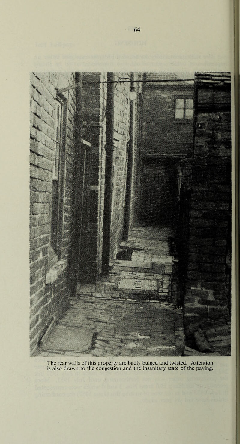 The rear walls of this property are badly bulged and twisted. Attention is also drawn to the congestion and the insanitary state of the paving.