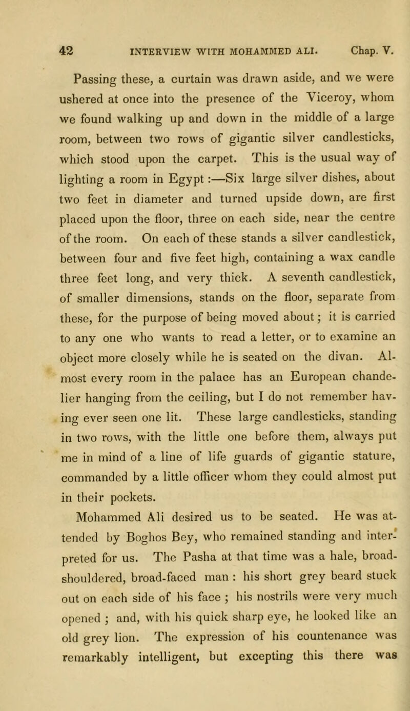 Passing these, a curtain was drawn aside, and we were ushered at once into the presence of the Viceroy, whom we found walking up and down in the middle of a large room, between two rows of gigantic silver candlesticks, which stood upon the carpet. This is the usual way of lighting a room in Egypt:—Six large silver dishes, about two feet in diameter and turned upside down, are first placed upon the fioor, three on each side, near the centre of the room. On each of these stands a silver candlestick, between four and five feet high, containing a wax candle three feet long, and very thick. A seventh candlestick, of smaller dimensions, stands on the floor, separate from these, for the purpose of being moved about; it is carried to any one who wants to read a letter, or to examine an object more closely while he is seated on the divan. Al- most every room in the palace has an European chande- lier hanging from the ceiling, but I do not remember hav- ing ever seen one lit. These large candlesticks, standing in two rows, with the little one before them, always put me in mind of a line of life guards of gigantic stature, commanded by a little officer whom they could almost put in their pockets. Mohammed Ali desired us to be seated. He was at- tended by Boghos Bey, who remained standing and inter- preted for us. The Pasha at that time was a hale, broad- shouldered, broad-faced man : his short grey beard stuck out on each side of his face ; his nostrils were very much opened ; and, with his quick sharp eye, he looked like an old grey lion. The expression of his countenance was remarkably intelligent, but excepting this there was