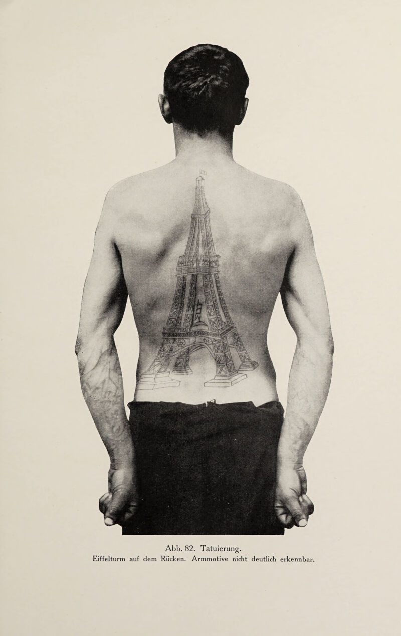 Eiffelturm auf dem Rücken. Armmotive nicht deutlich erkennbar. m*
