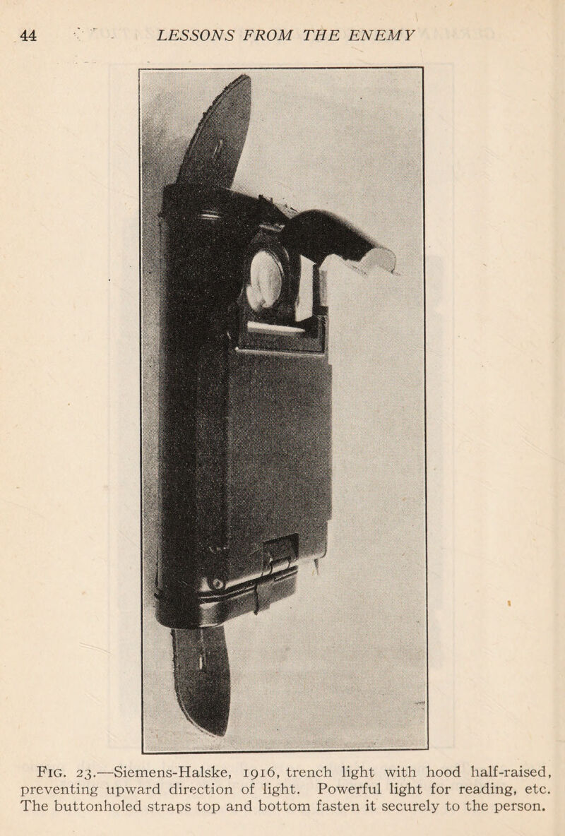 Fig. 23.—Siemens-Halske, 1916, trench light with hood half-raised, preventing upward direction of light. Powerful light for reading, etc. The buttonholed straps top and bottom fasten it securely to the person.