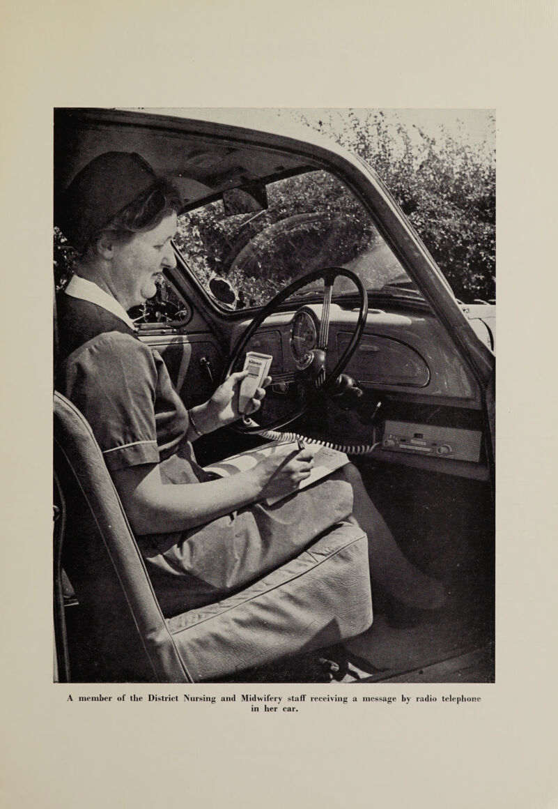 A member of llie District Nursing and Midwifery staff receiving a message by radio telephone in her car.