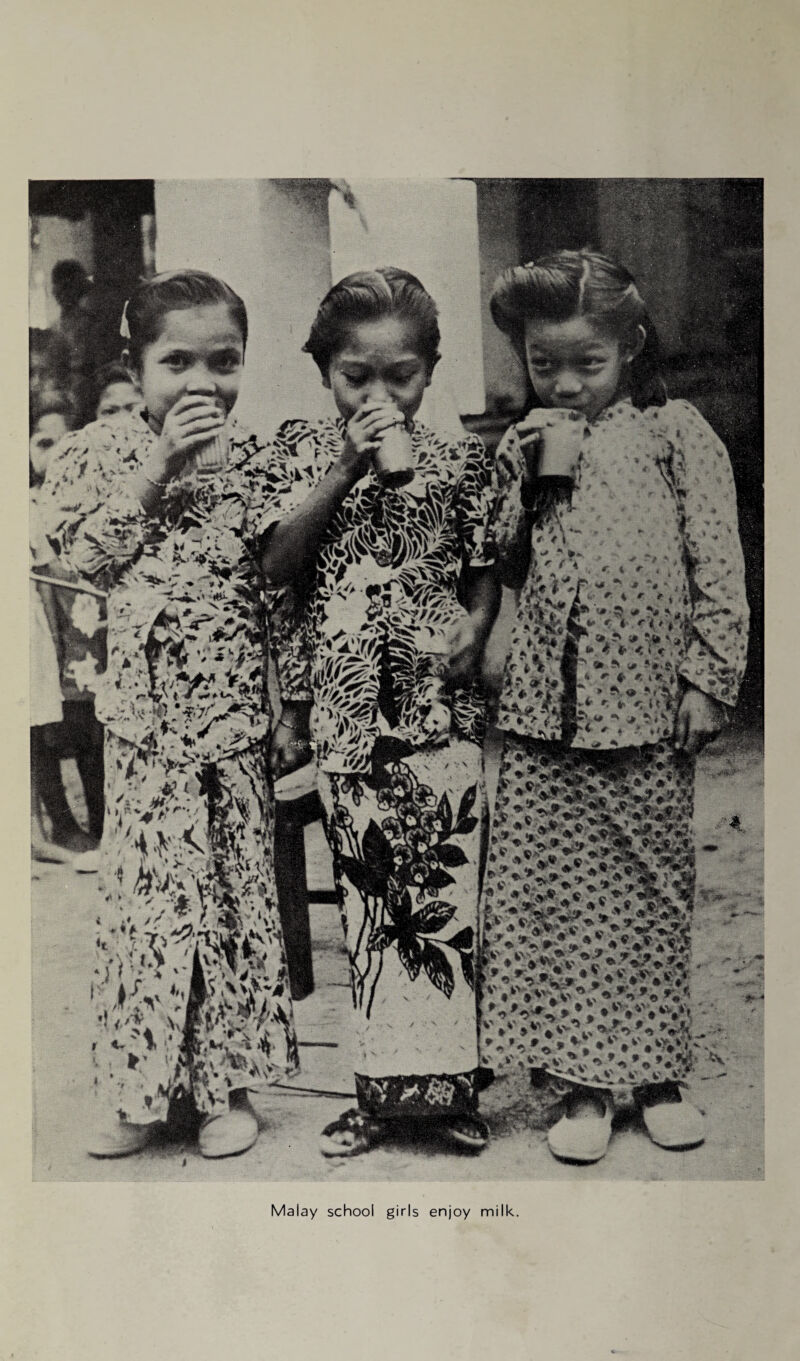 Malay school girls enjoy milk.