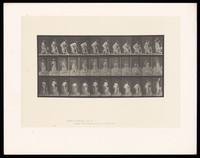 view A clothed woman stepping on to and off a trestle, lowering a jug over to the other side of it then raising the jug above her head. Collotype after Eadweard Muybridge, 1887.