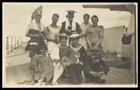 view Nine men dressed up on deck. Photographic postcard, 192-.