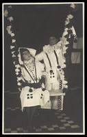 view Two British soldiers performing as clowns for "The Timbertown Follies", at a prisoner of war camp in Groningen. Photographic postcard, 191-.