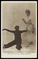 view Harold Chapman in drag poses with Mark Leslie dressed as a Golliwog, in an act for the Bow Bells. Photographic postcard, 191-.