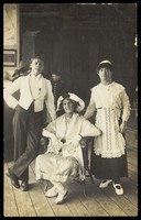 view Three soldiers, two in drag, pose in costume. Photographic postcard, ca. 1920.