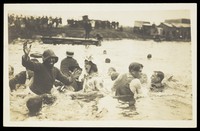 view A group of men, one in drag, swimming and playing in a river.