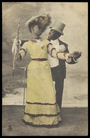 view Two black actors, one in drag, dance together on stage. Coloured process print, ca. 1903.