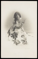 view A young man in drag poses in a flowery dress. Photographic postcard, 192-.
