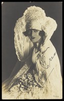 view Bert Errol, in character, wearing an elaborate white dress. Process print, 1925.