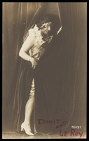 view An actor in character; posing with a curtain. Photograph, 19--.