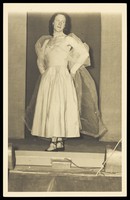 view A man in drag standing on a stage. Photographic postcard, 195-.