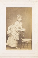 view A man in drag resting against a chair. Photograph, 187-.