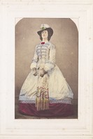 view A man in drag wearing an elaborate dress and feathered hat.