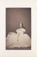 view A man in drag is sitting down wearing a large white dress. Photograph, 189-.