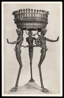 view A bronze tripod with three satyrs sculpted for the legs of the tripod. Photographic postcard, 195-.