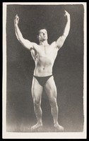 view An athletic man poses in dark briefs. Process print, 195-.