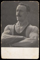 view A wrestler poses with his arms crossed. Process print, 19--.