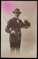 view A man holding flowers and a cane. Coloured photographic postcard, 1925.