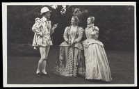 view An actor in Elizabethan costume in conversation with two actresses. Photographic postcard by J.W. Debenham, 193-.