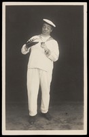 view Bert Murray in character as a sailor pouring himself a drink. Photographic postcard, 192-.