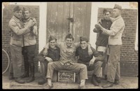 view Belgian military recruits celebrating the end of their training stint at Camp Beverlo. Photographic postcard, 192-.