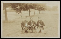 view Three French or Belgian soldiers arm-in-arm in a park smoking and drinking beer. Photographic postcard, 190- (?).