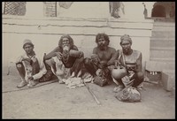 view A group of bearded men sitting on the ground.