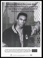 view A black youth wearing a gold chain and bomber jacket leans against a wire fence with a warning about the risk of sexually transmitted diseases in the young; a poster from the America responds to Aids advertising campaign. Lithograph, 1993.