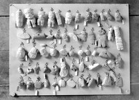 view M0001527: Photograph of a mounted display of amuletic heads and figures