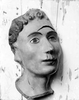 view M0001510: Photograph of a wax ex-voto of human head with a cut across the forehead and bloodied nose