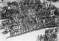 view M0001531: Photograph of rows of local workers holding papers and possibly waiting to receive their wages, at the campsite in Jebel Moya, Henry Wellcome's archeological excavation site in Sudan