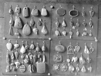 view M0001520: Photograph of four groups of mounted charms and amulets, chiefly heart and pear shaped stones mounted in metal