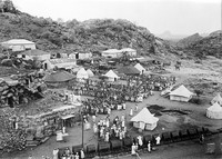 view M0001530: Photograph of the view of Jebel Moya, Henry Wellcome's archeological excavation site in Sudan, and a large gathering of local workers within the campsite