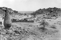 view M0001535: Photograph of the view over the excavations at Jebel Moya, Henry Wellcome's archeological site in Sudan, with a stone incinerator in the foreground (left)