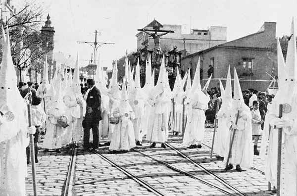 M0001817: Photograph of a procession of Catholic brotherhoods (cofradía) during the annual annual tribute of the Passion of Jesus Christ called Holy Week (Semana Santa) in Seville, Andalucia during Easter