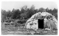 view M0002427: Two Ojibwe women sitting by a fire and tent, Detroit Lakes, Minnesota