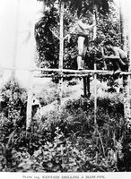 view M0005517: Kenyahs hollowing out a blowpipe, Borneo